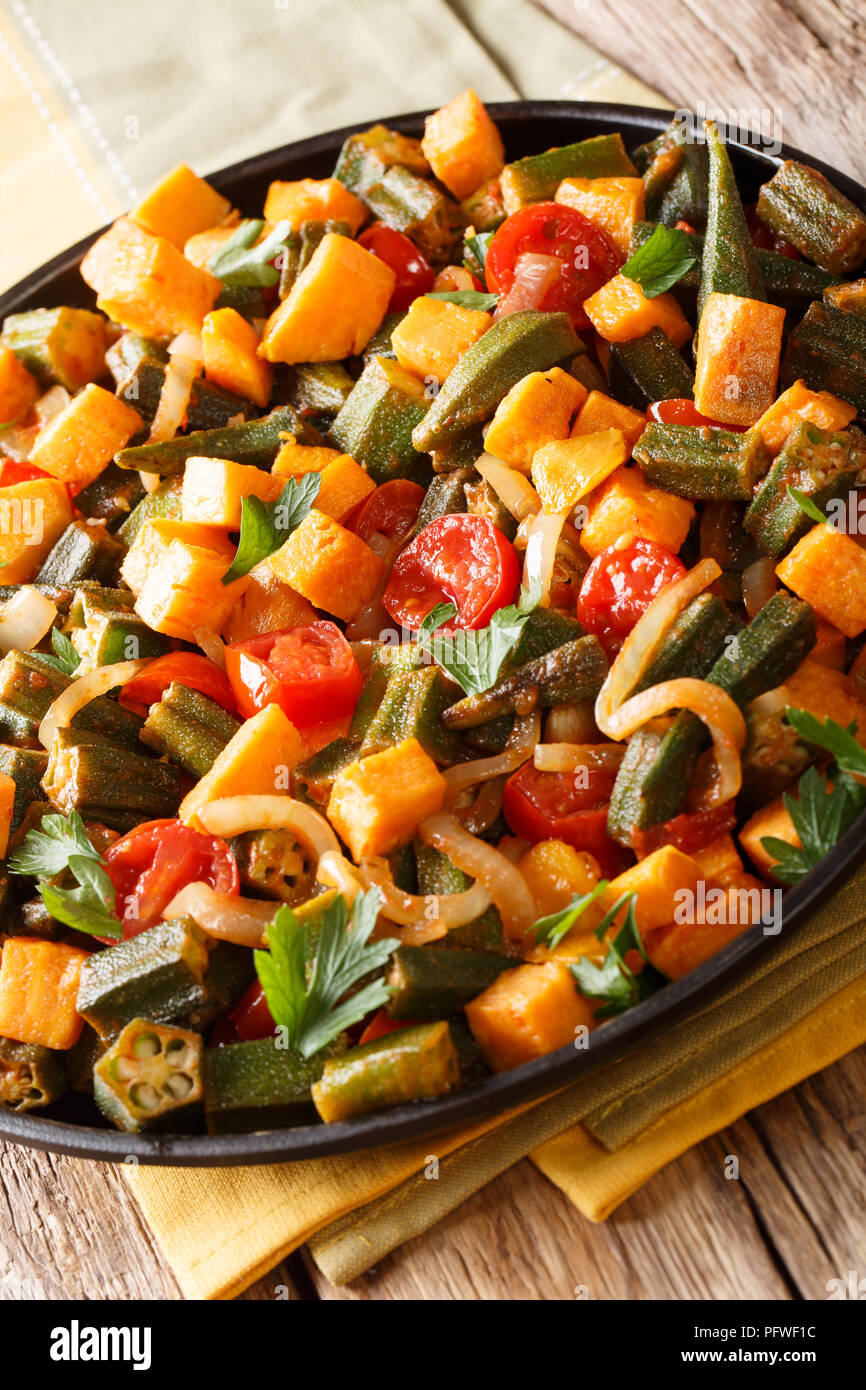 Gemüseeintopf okra, süße Kartoffeln, Tomaten, Zwiebeln und Kräutern closeup auf einem Teller auf den Tisch. Vertikale Stockfoto