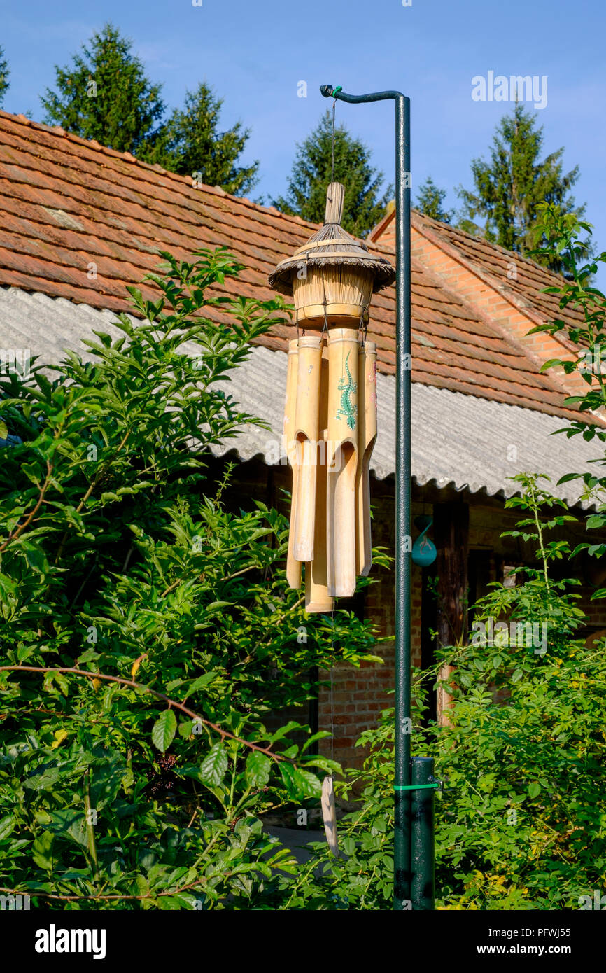 Balinesische Bambus Windspiele hängend aus der Pole im Garten von einem Haus im Dorf in Zala Ungarn Stockfoto