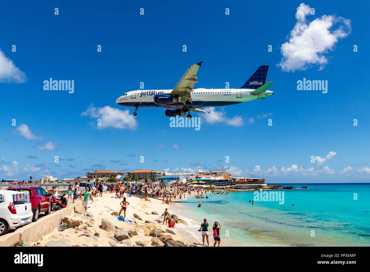 Eine Jetblue Flug geht über Maho Beach und Dutzende Touristen kurz vor der Landung am Princess Juliana International Airport in Saint Martin. Stockfoto