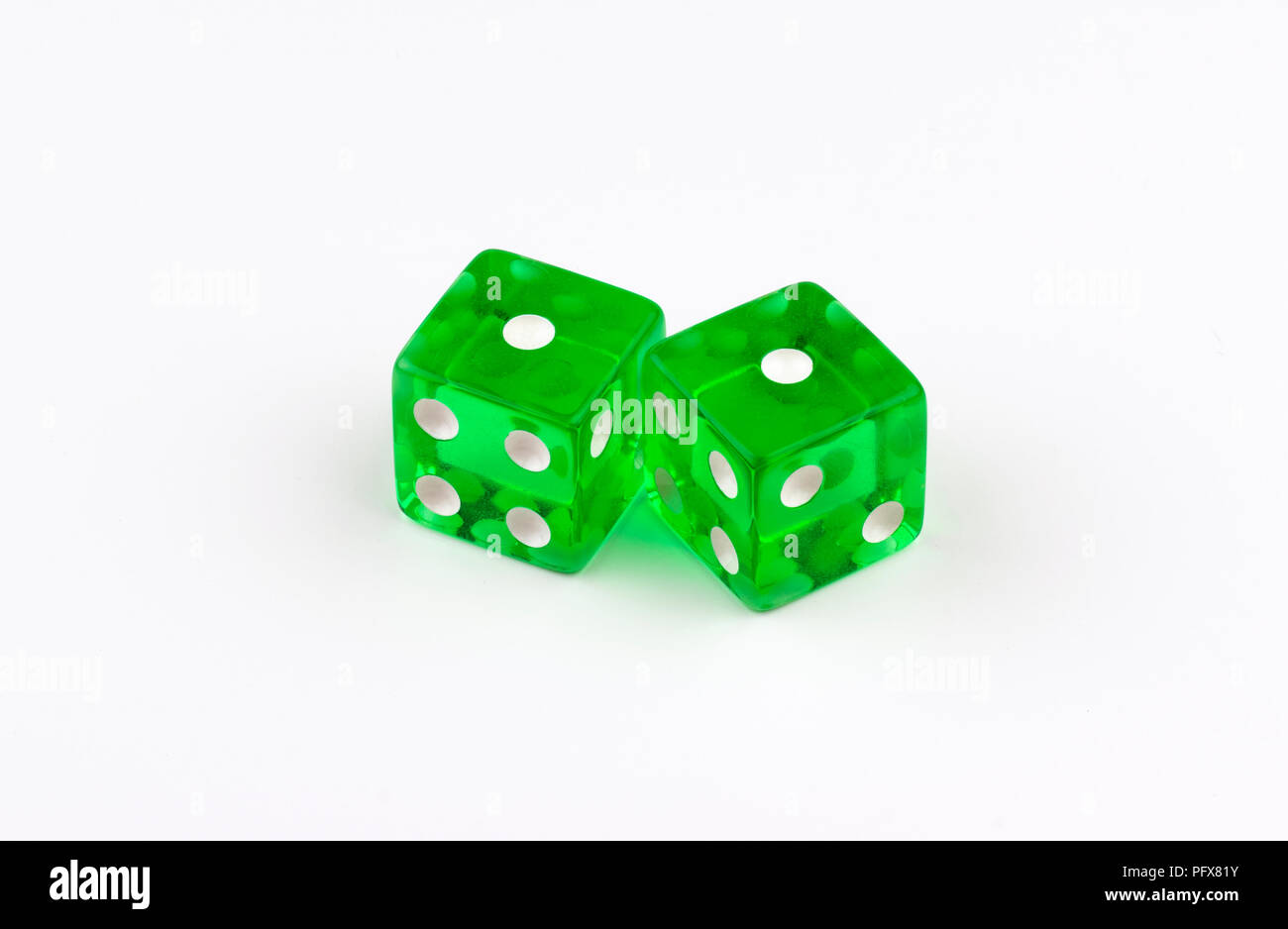 Ein Paar grüne, durchscheinende Spielwürfel auf weißem Hintergrund mit ihren Flecken, die ein Paar von ihnen zeigen, oder unglückliche Schlangenaugen im Spiel mit Craps. Stockfoto