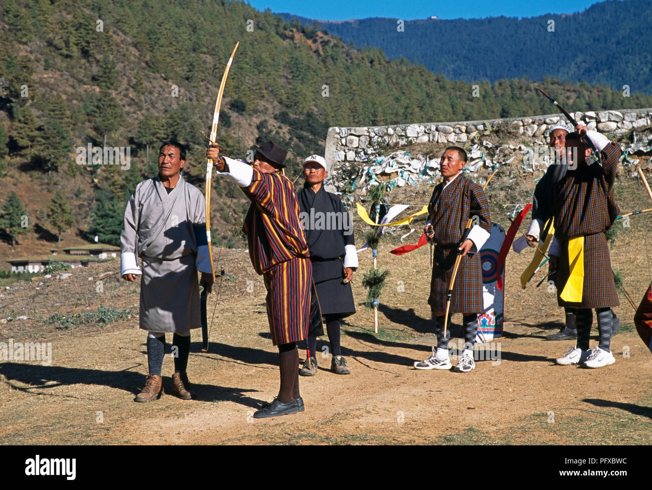 Die Teilnehmer tragen die nationalen Kleid am Sonntag Bogenschießen Wettbewerb in der Nähe von Paro in Bhutan für redaktionelle NUR VERWENDEN Stockfoto