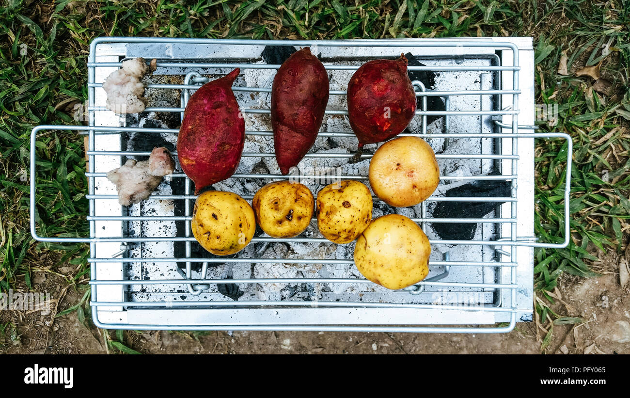 Brazier Kohle und gebackene Süsskartoffeln und Kartoffeln geröstet Stockfoto