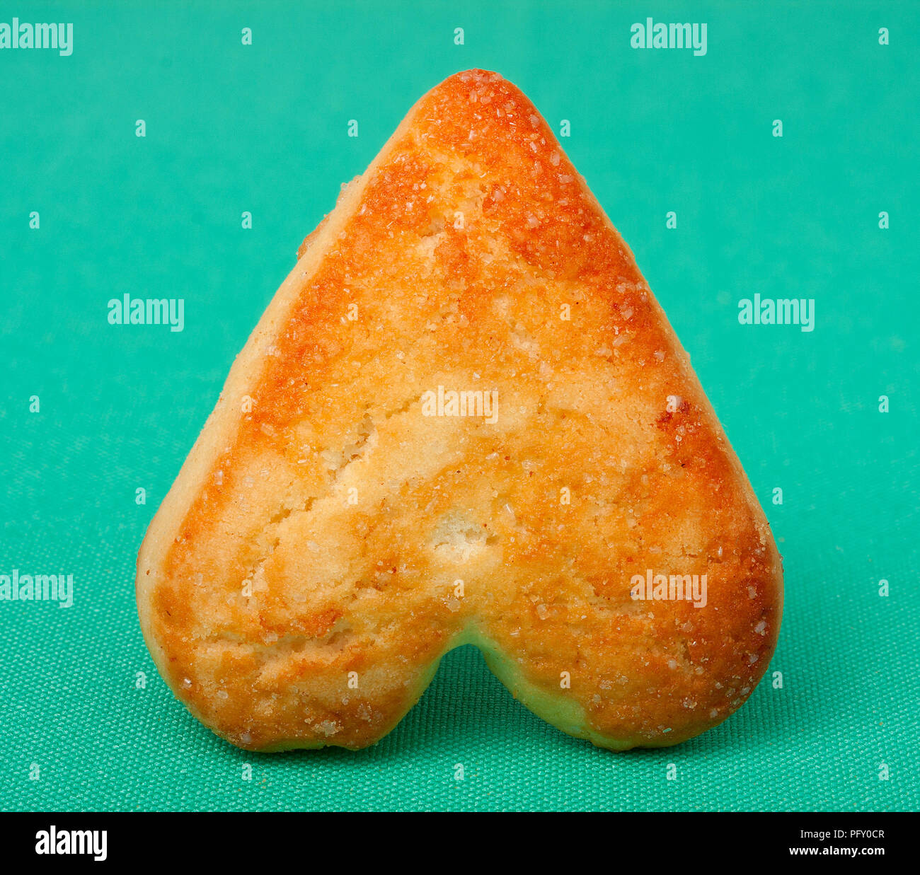 Ein Cookie in der Form von Herzen auf grünem Hintergrund Stockfoto