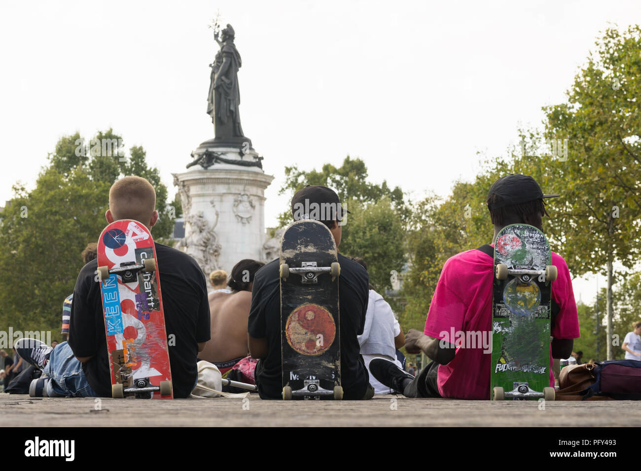 Paris Skater - Drei Pariser Jungen von hinten lehnte sich auf ihren Skateboards auf dem Place de la Republique. Frankreich, Europa. Stockfoto