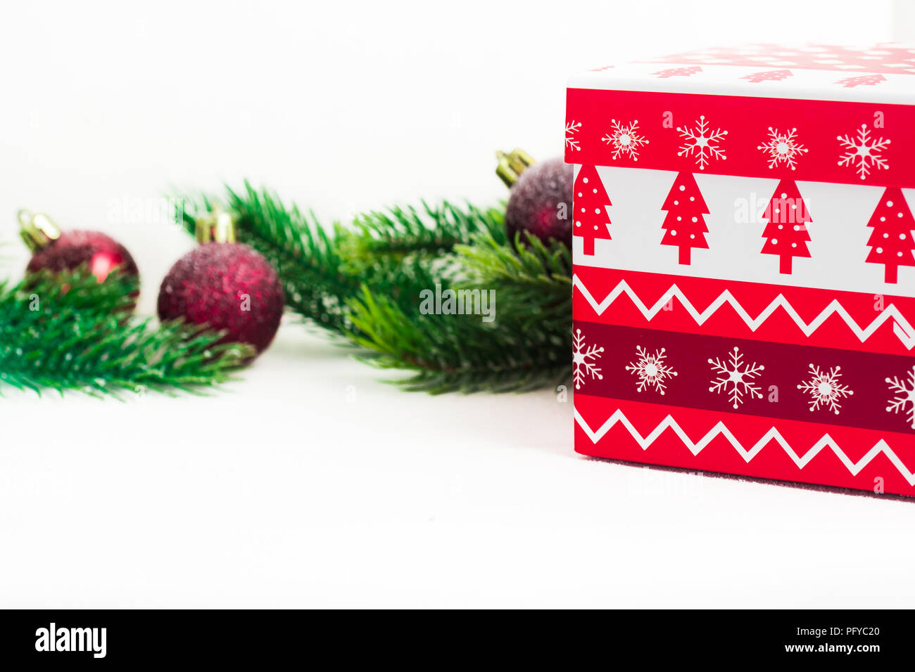 Tannenzweigen auf Weiß mit Weihnachten Spielzeug eingerichtet, Geschenkbox auf Weiß. Platz für Text. Stockfoto