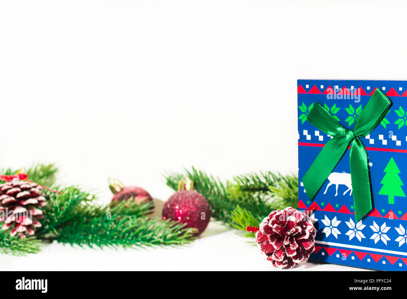 Tannenzweigen auf Weiß mit Weihnachten Spielzeug eingerichtet, Geschenkbox auf Weiß. Platz für Text. Stockfoto