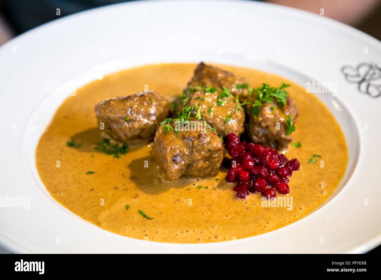 Schwedische Fleischbällchen in einer Sauce mit Preiselbeeren Sauce auf einer Platte Stockfoto