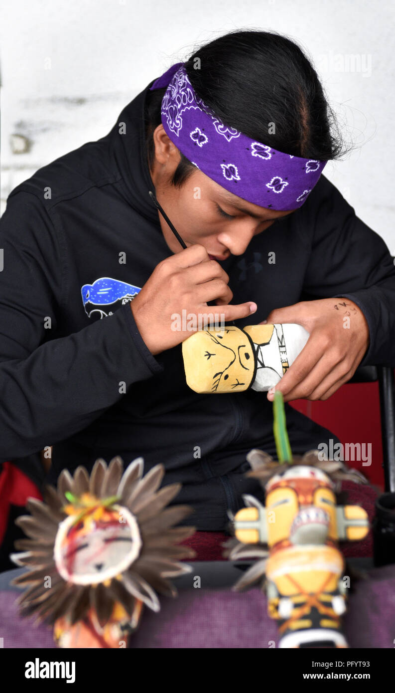 Eine junge Native-American (Hopi) Künstler malt eine traditionelle Hopi Kachina Puppe in der Santa Fe indischen Markt. Stockfoto