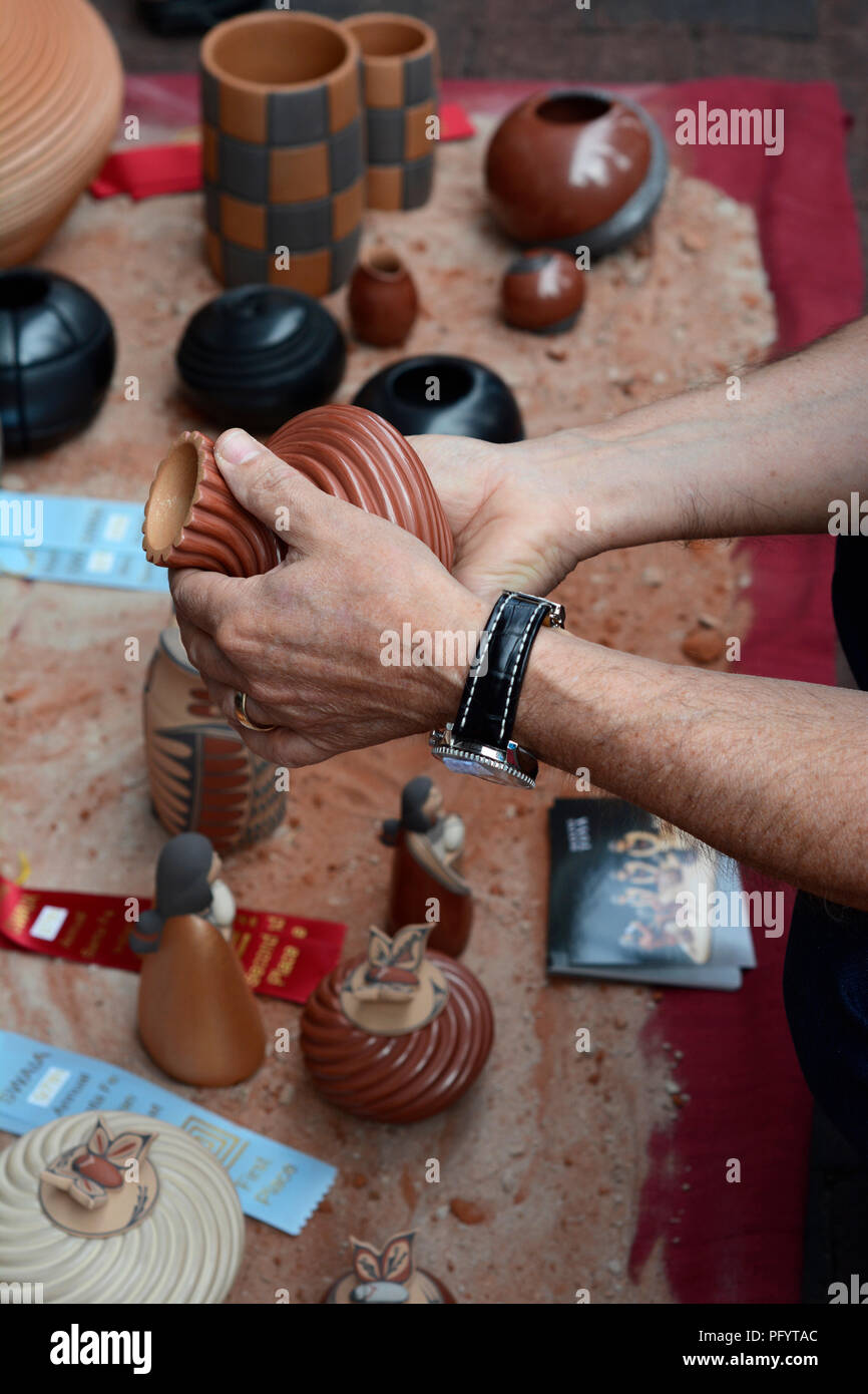 Ein Kunde prüft eine Native-American Ton Schiff zum Verkauf in der Santa Fe indischen Markt. Stockfoto