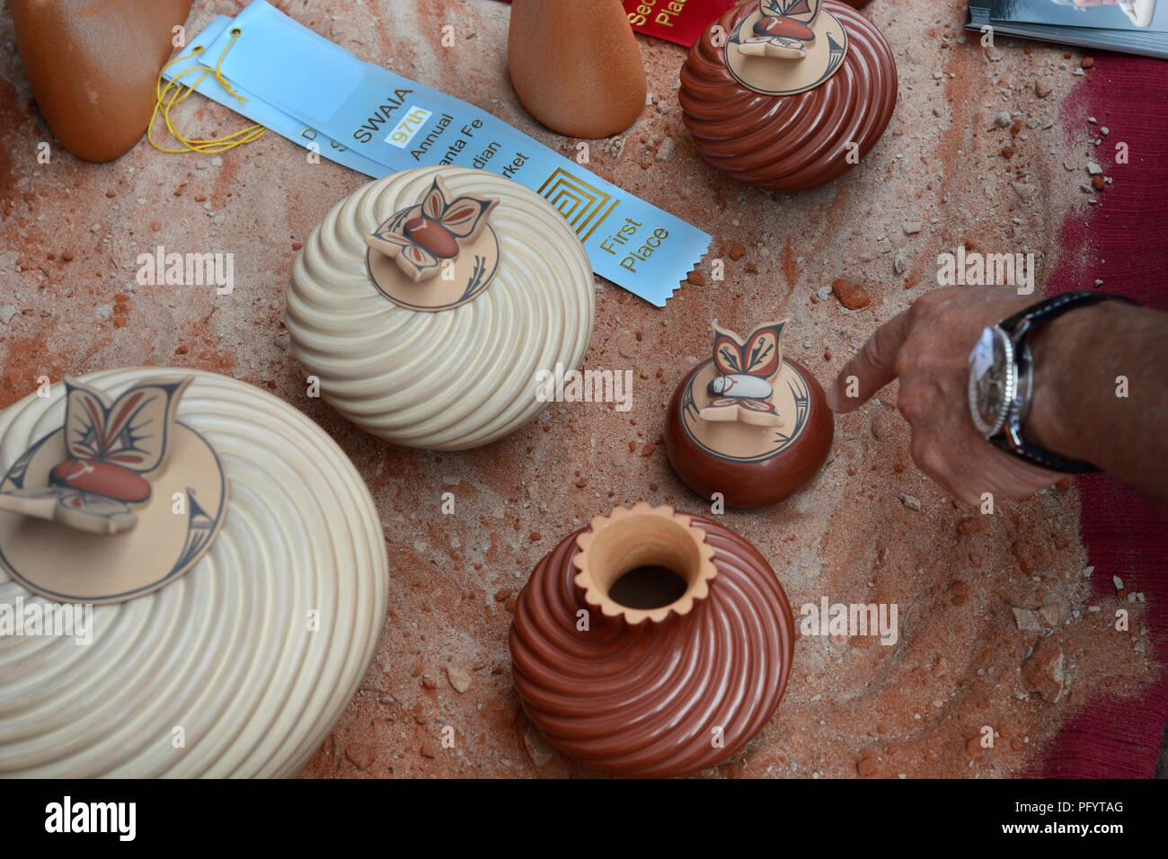 Ein Kunde deutet auf eine Native-American Ton Schiff zum Verkauf in der Santa Fe indischen Markt. Stockfoto