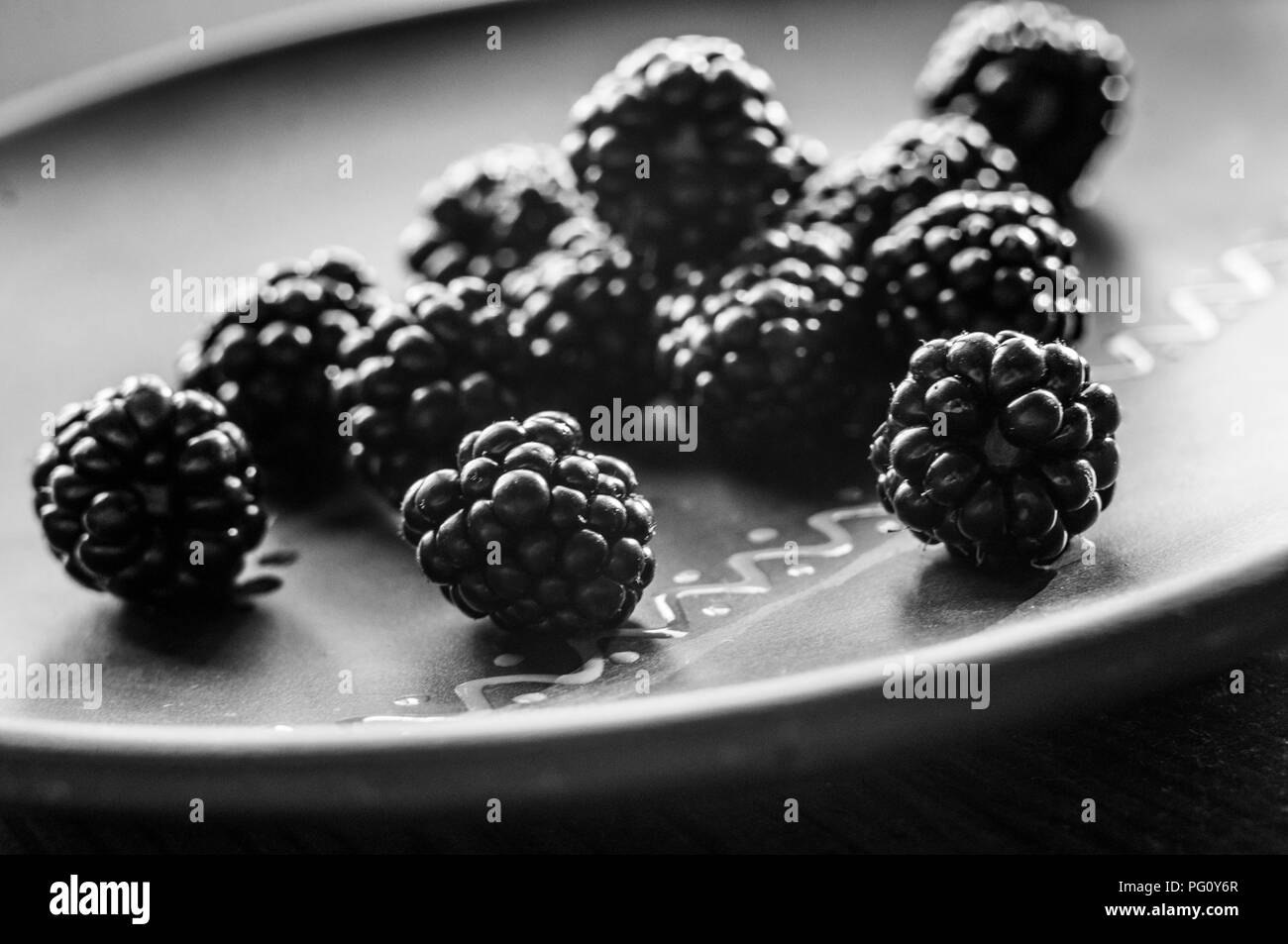 Große saftige frische Black Beeren auf einer Keramikplatte, close-up Stockfoto