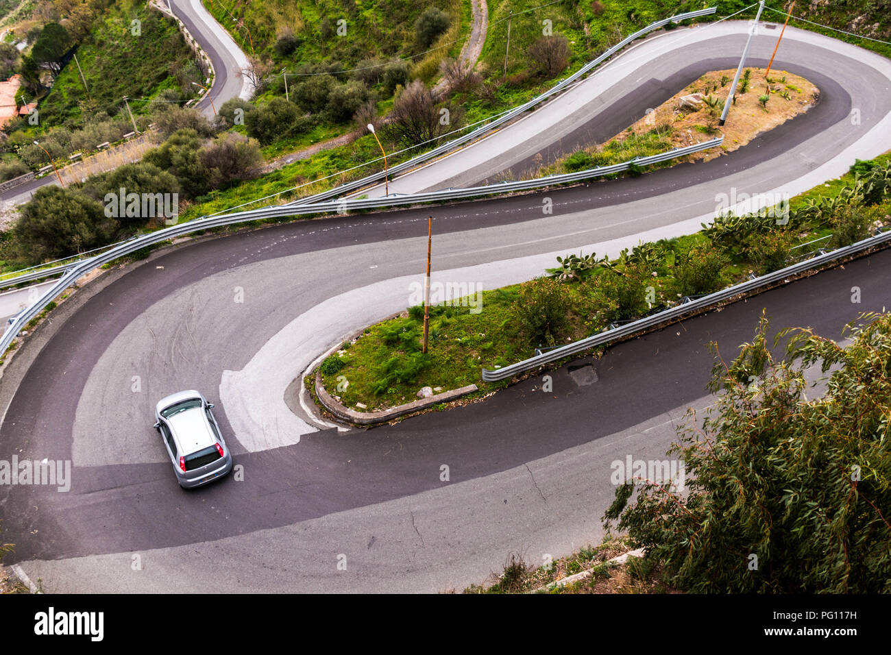 Ein Auto, eine scharfe Kurve auf einer kurvigen Serpentinenstraße in der Nähe von Forza D'Agro, Sizilien, Italien Stockfoto