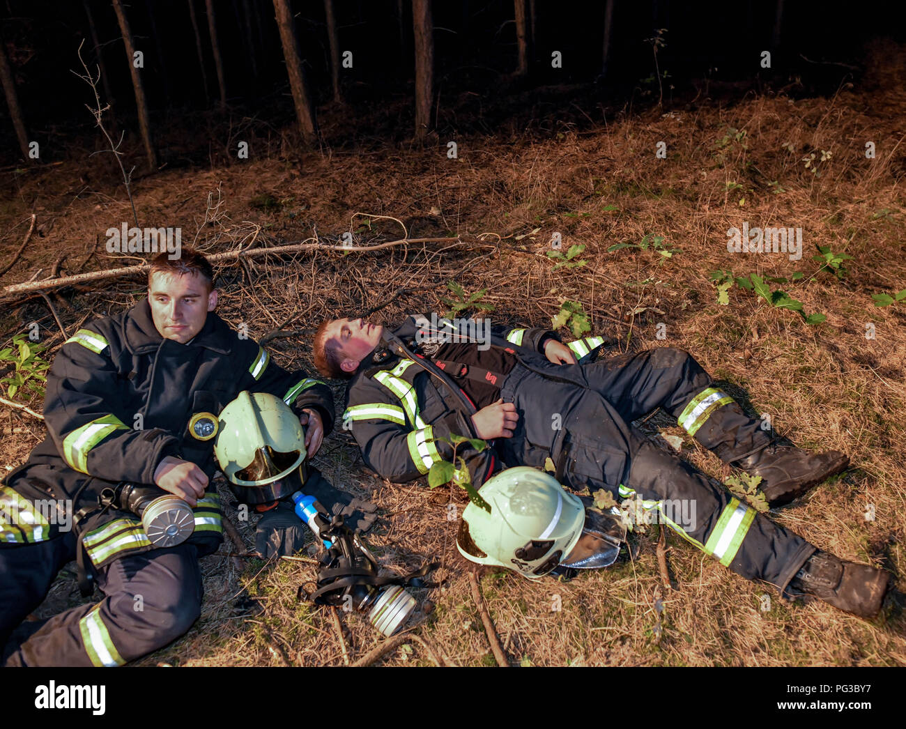 Jávea, Deutschland. 24 Aug, 2018. 24.08.2018, Brandenburg, Jávea: Zwei erschöpfte Kameraden der freiwilligen Feuerwehr Rest nach ihrer Bereitstellung. Hat sich ein Brand zu einer großen Wald im Südwesten von Brandenburg verteilen. Rund 300 Einsatzkräften Kämpfen der Waldbrand im Südwesten von Berlin. Die Behörden haben drei Dörfer evakuiert. Foto: Patrick Pleul/dpa-Zentralbild/dpa/Alamy leben Nachrichten Stockfoto