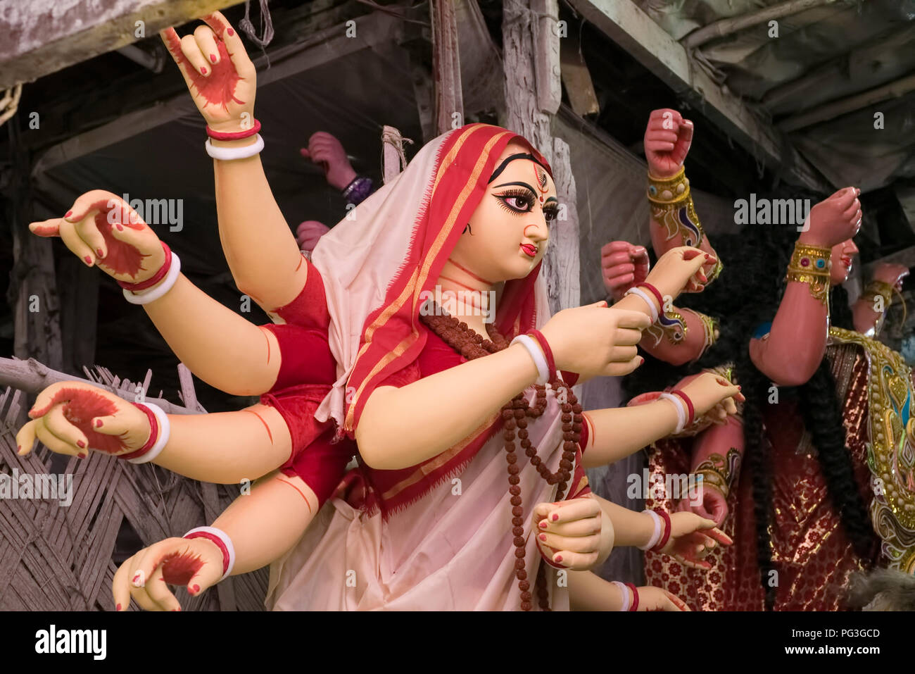 Kumartuli, gebildet, Ton Idol, der Göttin Durga, in rot gekleidet, grenzt ehite Lende Faserpapier mit Rudraksha Perlen Girlande, Kolkata, Indien. Stockfoto