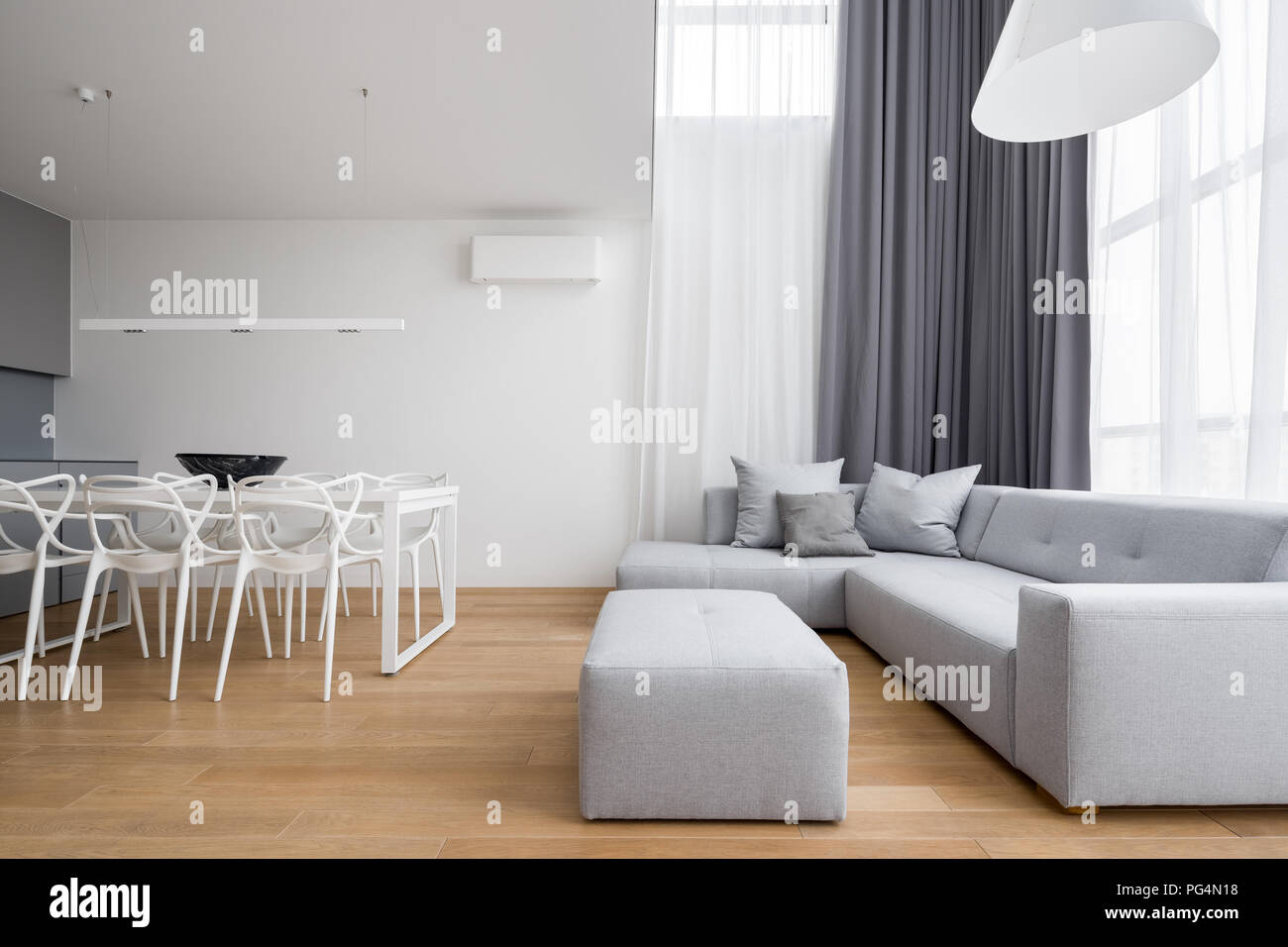 Minimalistisches Design Home Interior mit Ecksofa, weiß Tisch und moderne Stühle Stockfoto