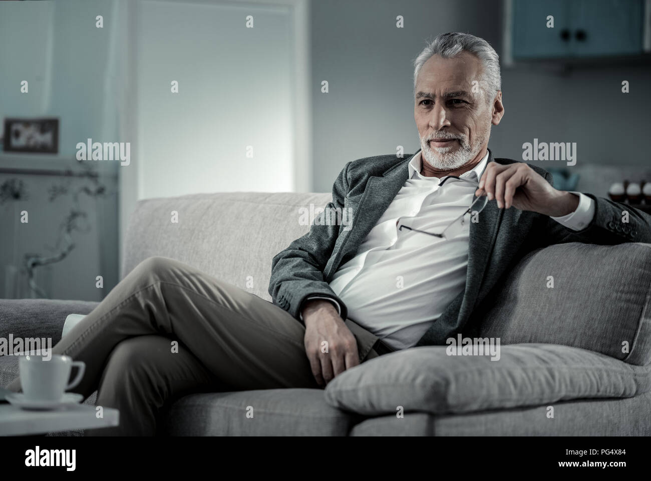 Entspannt bärtiger Mann saß auf der Couch Stockfoto Entspannt bärtiger Mann saß auf der Couch Stockfoto