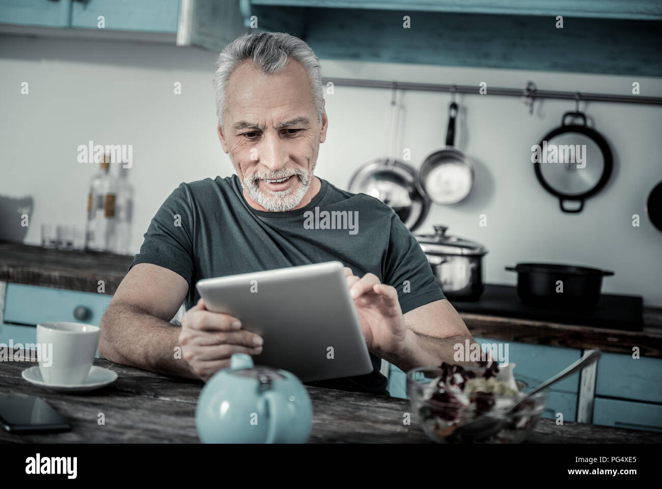 Stattliche reifer Mann in der Küche sitzt Stockfoto