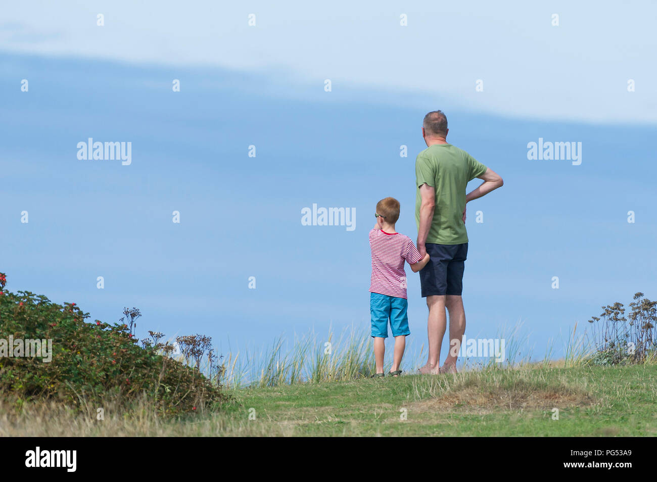 Vater und Sohn stehen an der Küste in Newquay Cornwall. Stockfoto