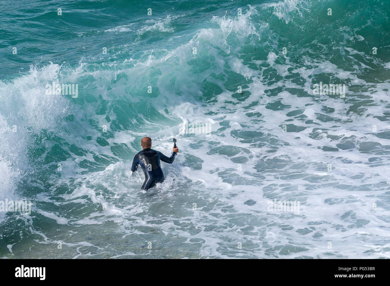 Einen Urlauber im Meer Holding eine wasserdichte GoPro Kamera. Stockfoto