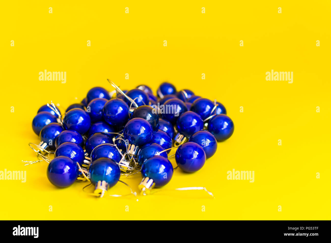 Stapel der blaue Weihnachtskugeln auf gelbem Hintergrund Stockfoto