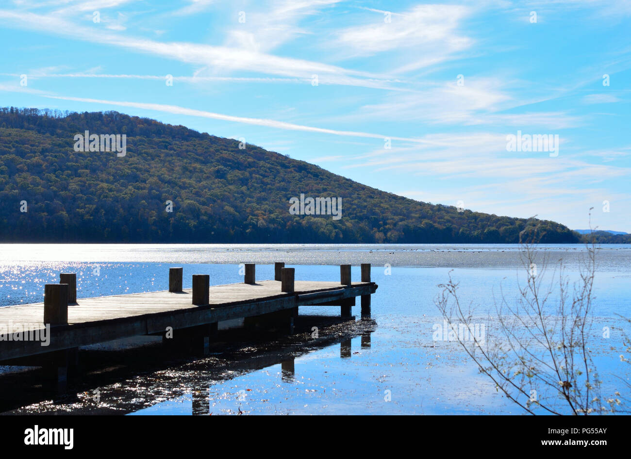 Holz dock Verlängerung über den See Wasser. Wunderschöne, ruhige und gelassene Bilder Bild von hölzernen Pier mit blauem Wasser und blauem Himmel, die fernen Hügel im Hintergrund. Stockfoto