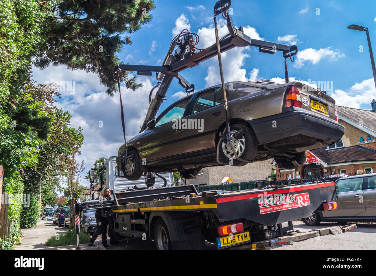 A 1992 Nissan Primera 2.0 LSI Automatik Limousine Auto auf einem Mercedes Atego recovery Lkw für Recycling, South Woodford, London, England angehoben Stockfoto