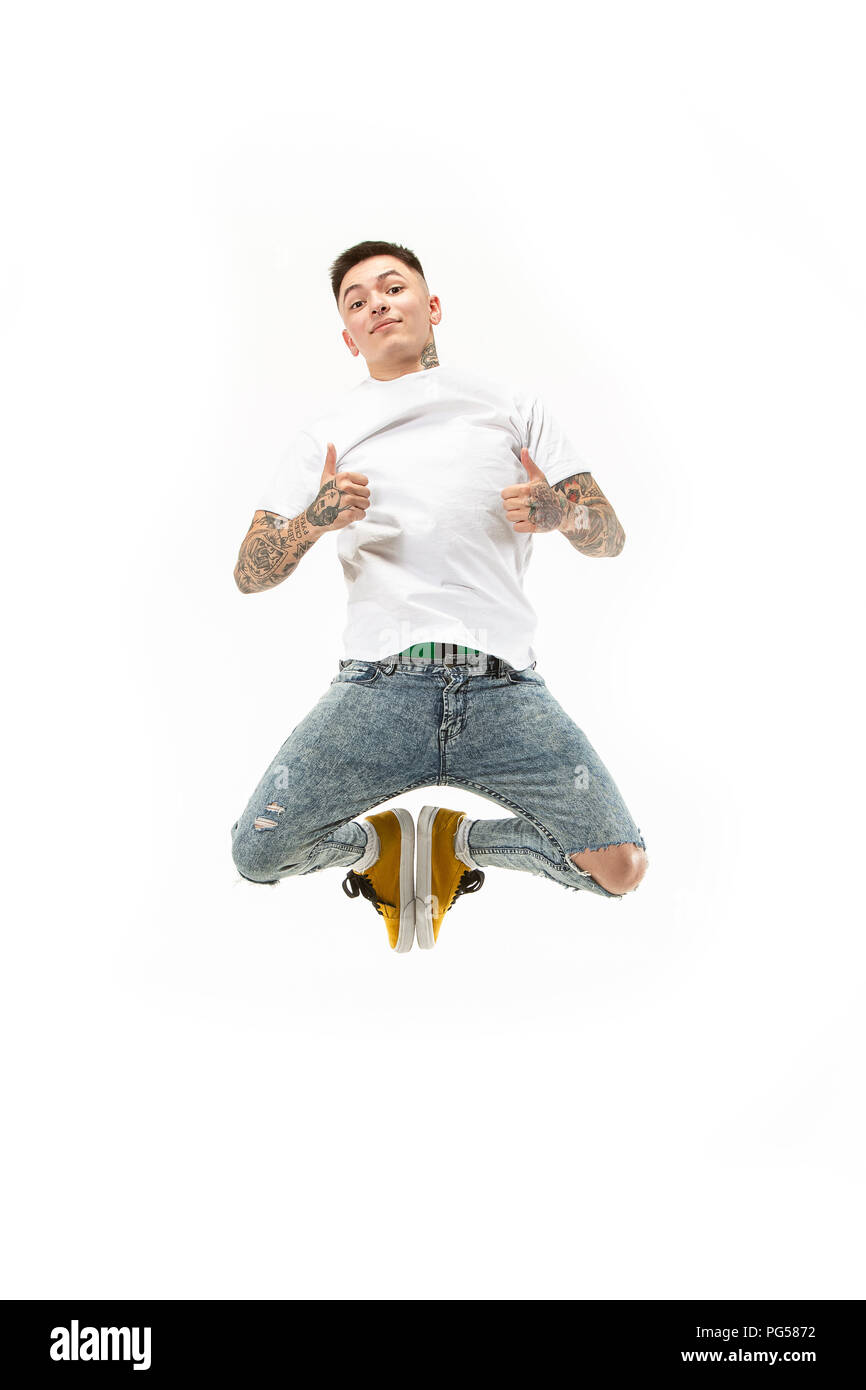 Springen junger Mann über weiße studio Hintergrund über Laptop beim Springen. Stockfoto