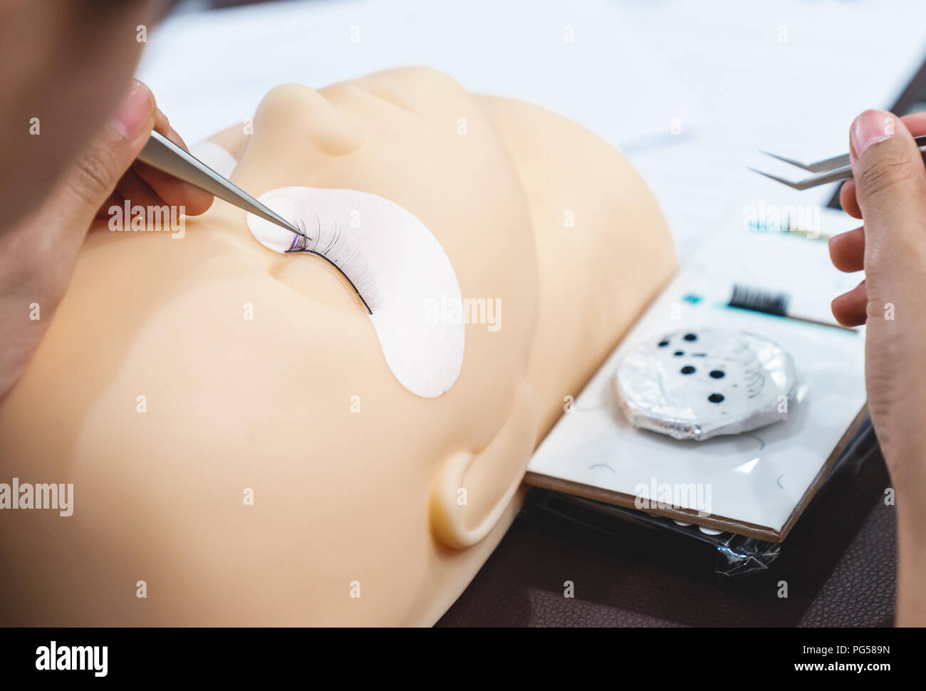 Nahaufnahme Ausbildung für permanent Eyelash Extension auf Silikon Schaufensterpuppe Kopf, der Studie und der Fähigkeit, die Arbeit mit einer Pinzette Stockfoto
