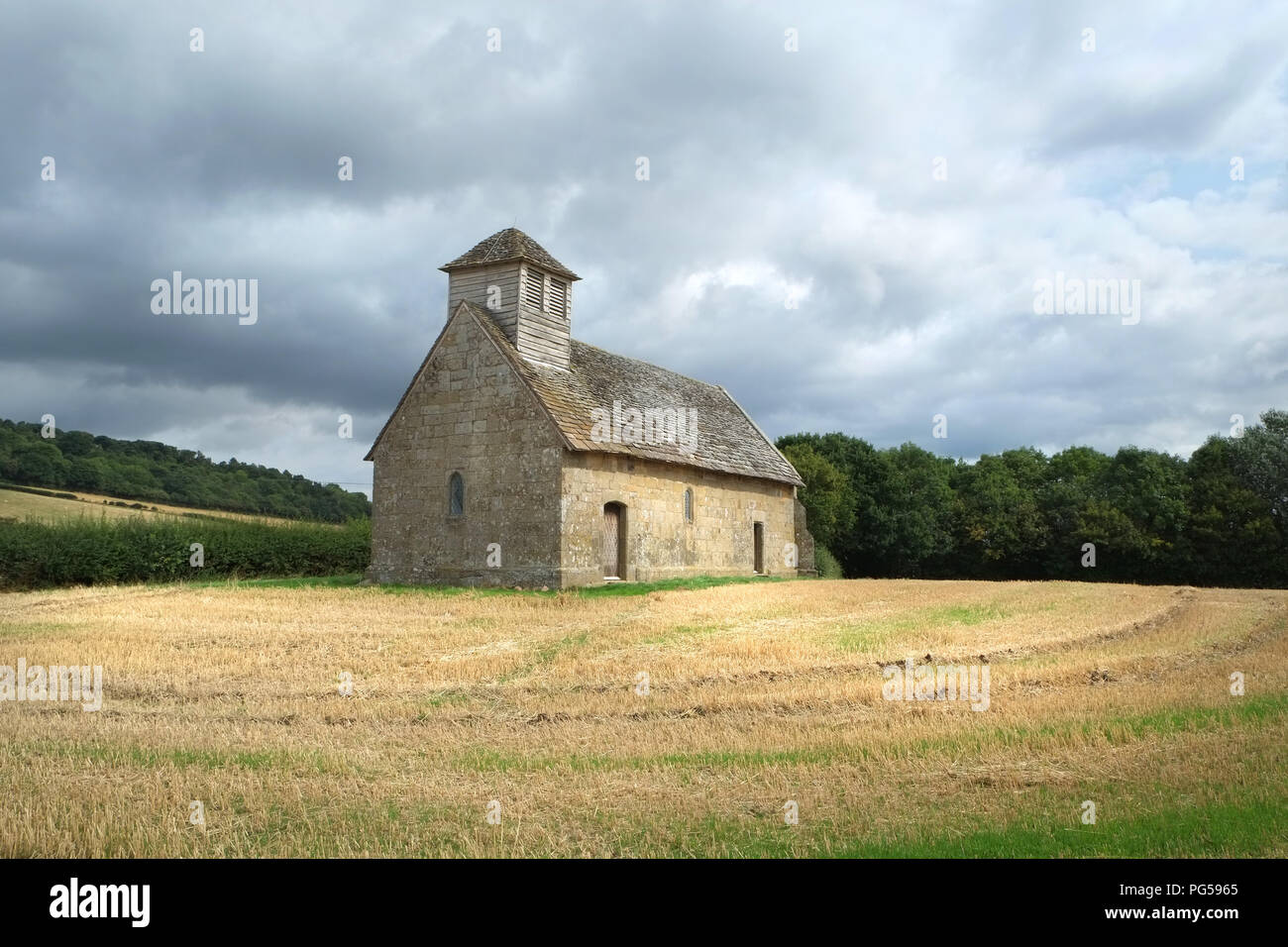 Langley Chapel, Acton Burnell, Shropshire, England, Großbritannien. Gesehen, nachdem das Maisfeld, in dem es steht, geerntet wurde. Bedrohlicher Himmel über uns Stockfoto