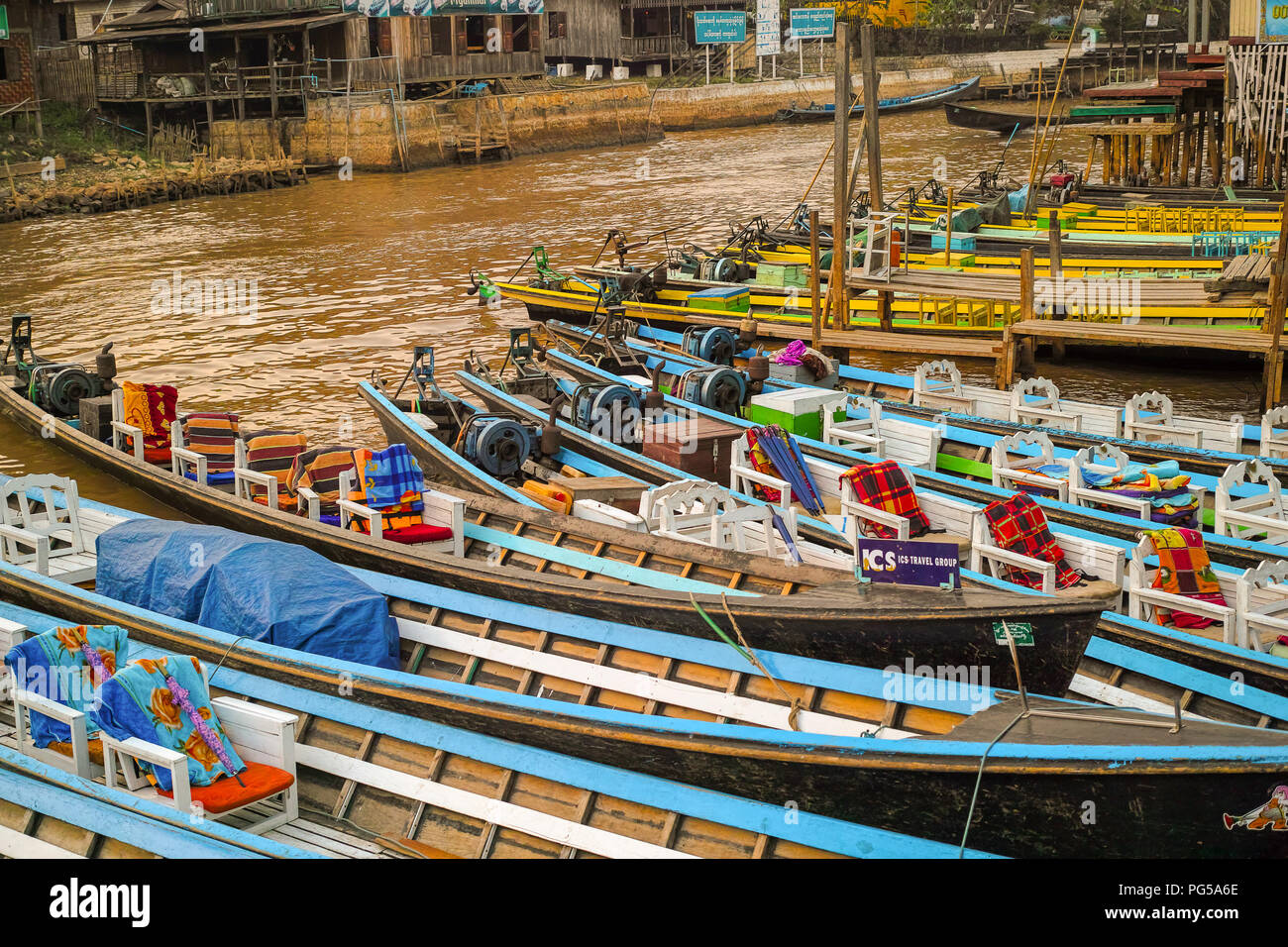 Bunte lange hölzerne Boote für Touristen am Pier in Nyaungshwe, Myanmar. 28 Feb. 2015 Stockfoto