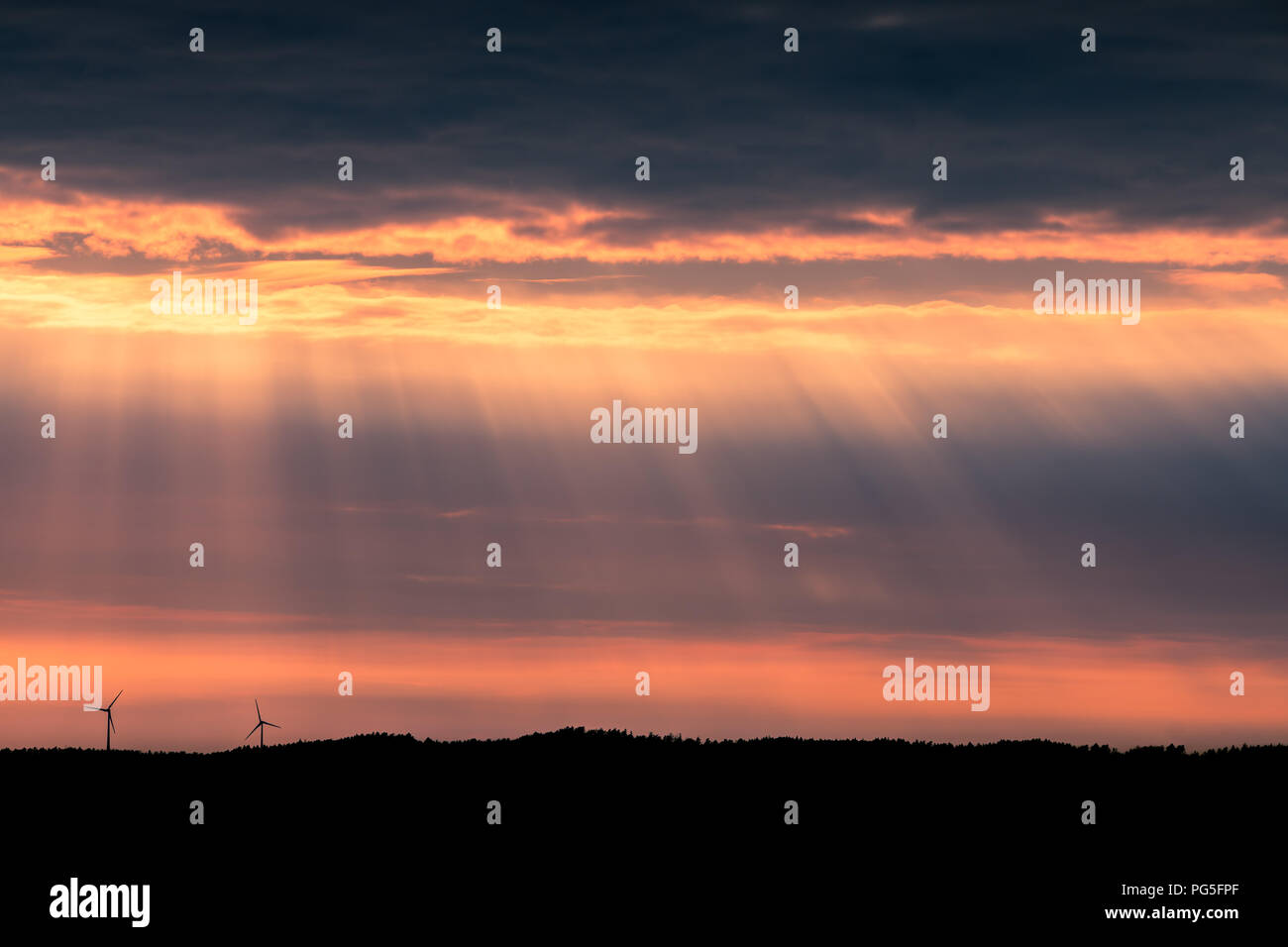 Eine einsame Windturbine auf einem Hügel bei Sonnenuntergang in der Nähe von Uddevalla, an der Westküste von Schweden. Sonnenstrahlen (besser bekannt als Sonnenstrahlen bekannt) Stockfoto