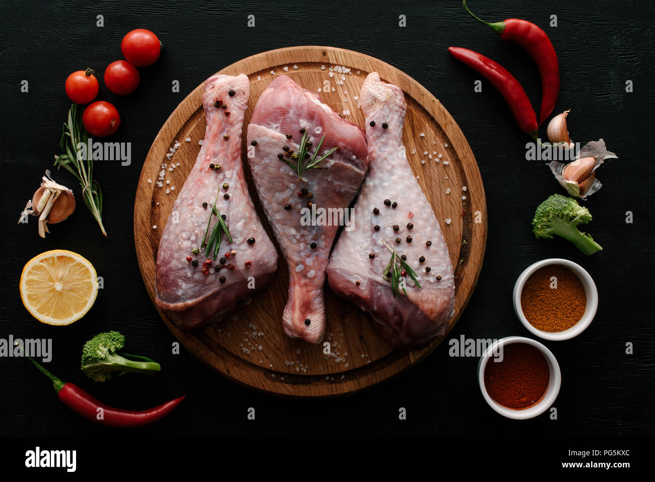 Flach mit der Türkei Beine auf Holz Schneidebrett mit Gemüse und Gewürze Stockfoto