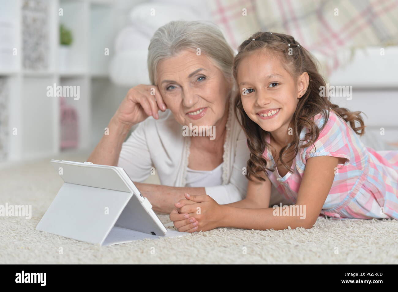 Süße kleine Mädchen mit ihrer Großmutter auf tatble Stockfoto
