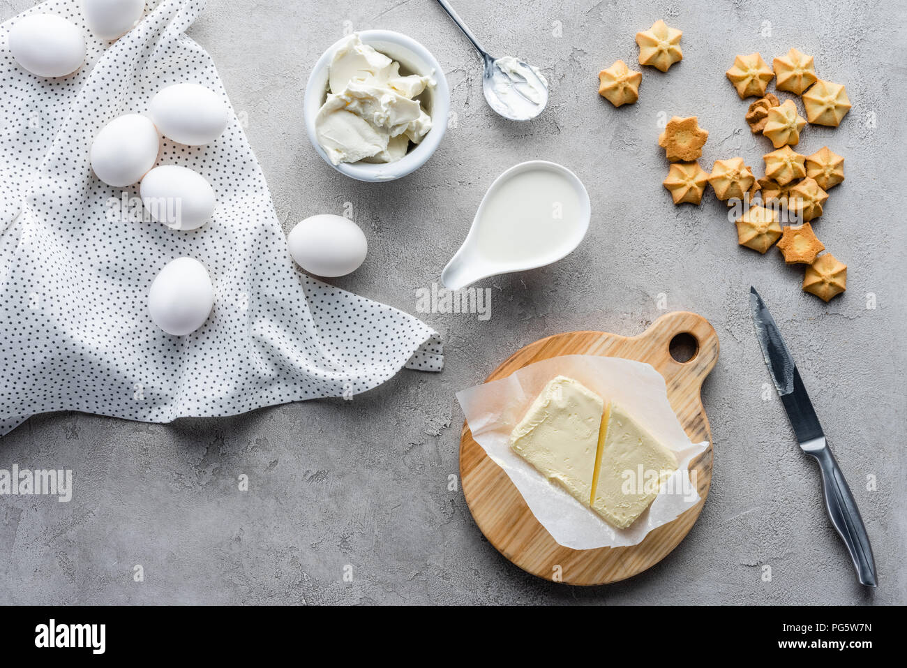 Flach mit geschnittenen Butter, Cookies und rohem Huhn eier Zutaten für eine Torte auf graue Oberfläche Stockfoto