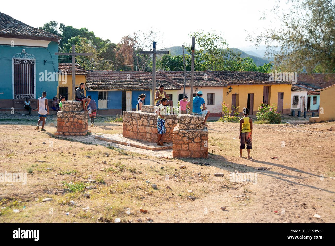 Kubanische Jugendliche spielen Fußball auf Abfall Boden in Trinidad mit traditionellen Haus im Hintergrund Stockfoto