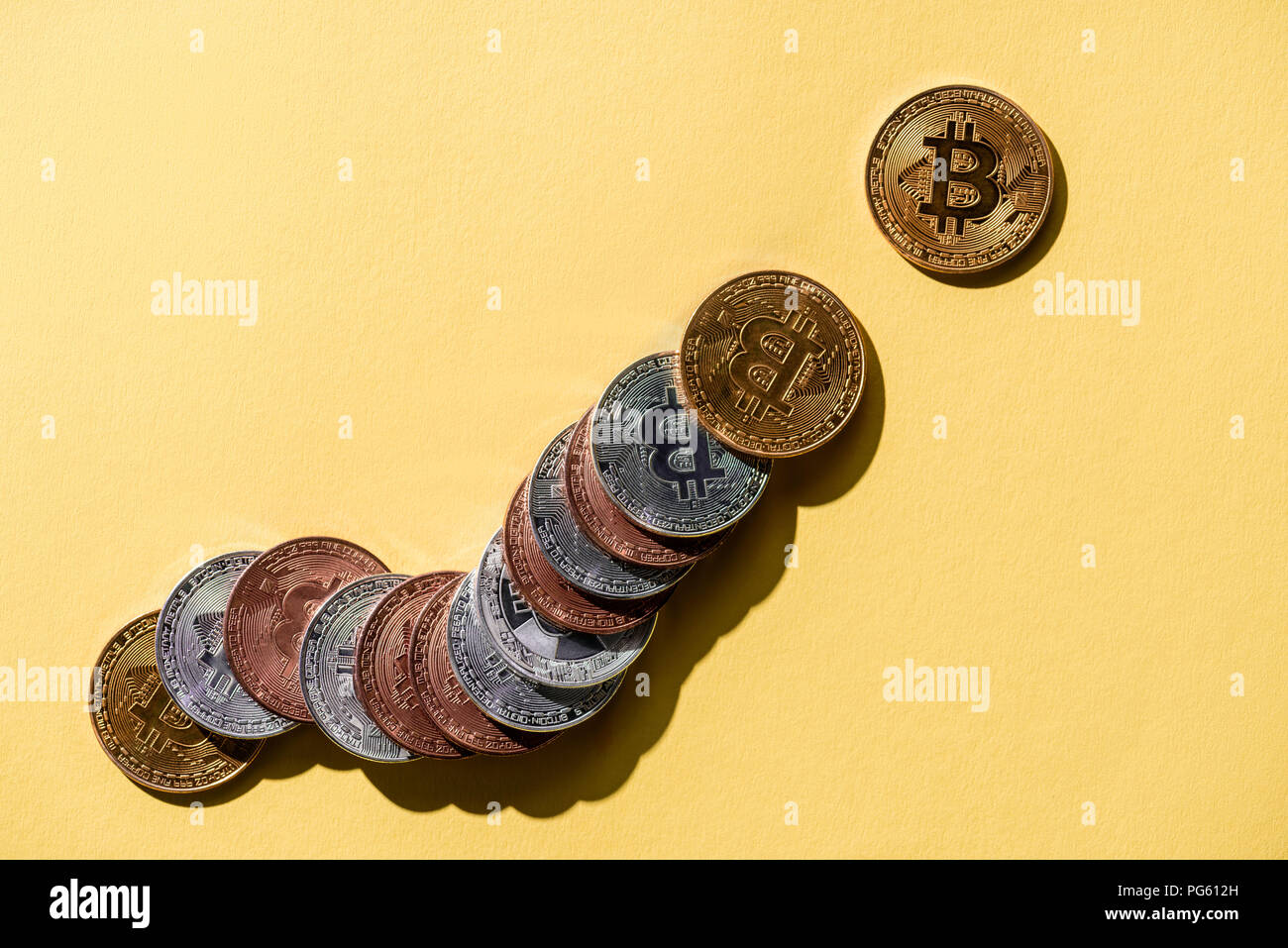 Ansicht von oben angeordnet verschiedene Bitcoins auf gelb Tischplatte Stockfoto