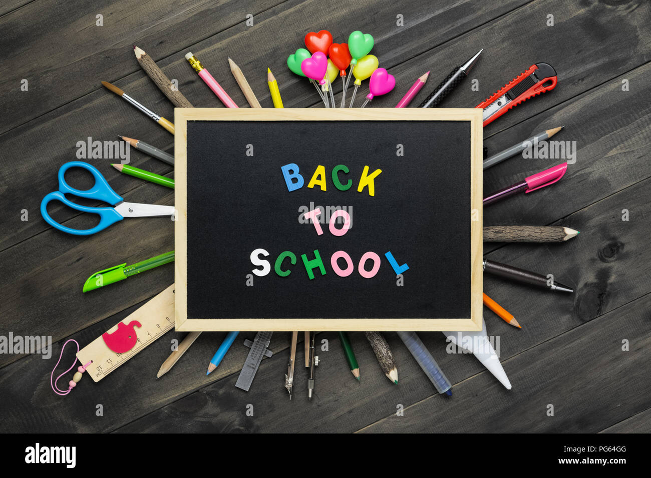Zurück zu Schule Hintergrund Konzept. Zurück zu Scool Holz text auf blackboard auf Holz Hintergrund mit Schulbedarf, Schreibwaren Accessoires. Flach Stockfoto