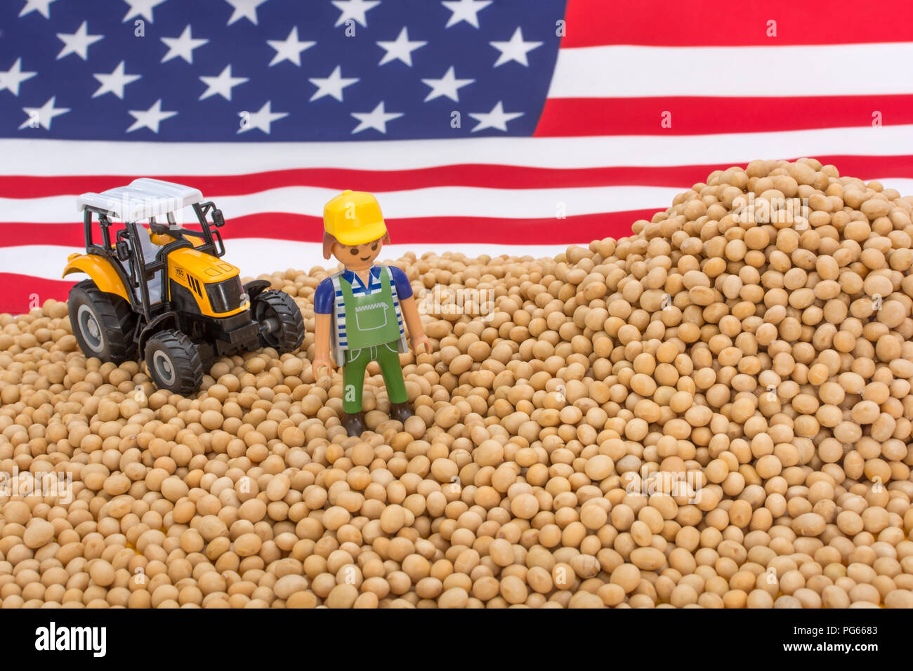Amerikanische Flagge mit Blocklagerung Sojabohnen. Metapher US-China trade Krieg, China trade Tarife, US-Sojabohnen Landwirtschaft, amerikanische Landwirte, Soja Ware Stockfoto