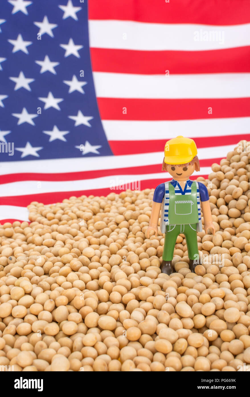 Amerikanische Flagge mit Blocklagerung Sojabohnen. Metapher US-China trade Krieg, China trade Tarife, US-Sojabohnen Landwirtschaft, amerikanische Landwirte, Soja Ware Stockfoto