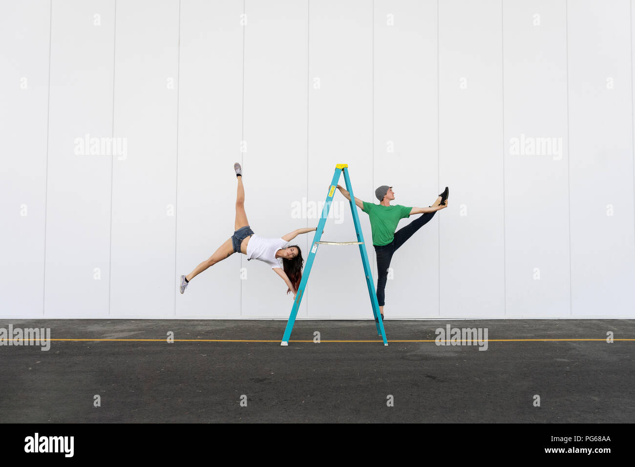 Zwei Akrobaten Tricks auf einer Leiter Stockfoto