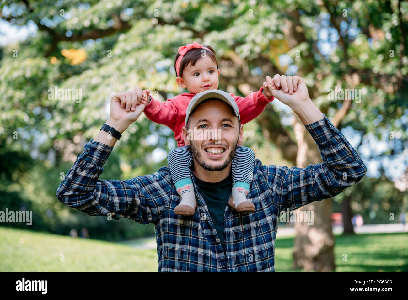 USA, New York, Vater mit Baby Mädchen auf seinen Schultern zu Fuß durch den Central Park Stockfoto