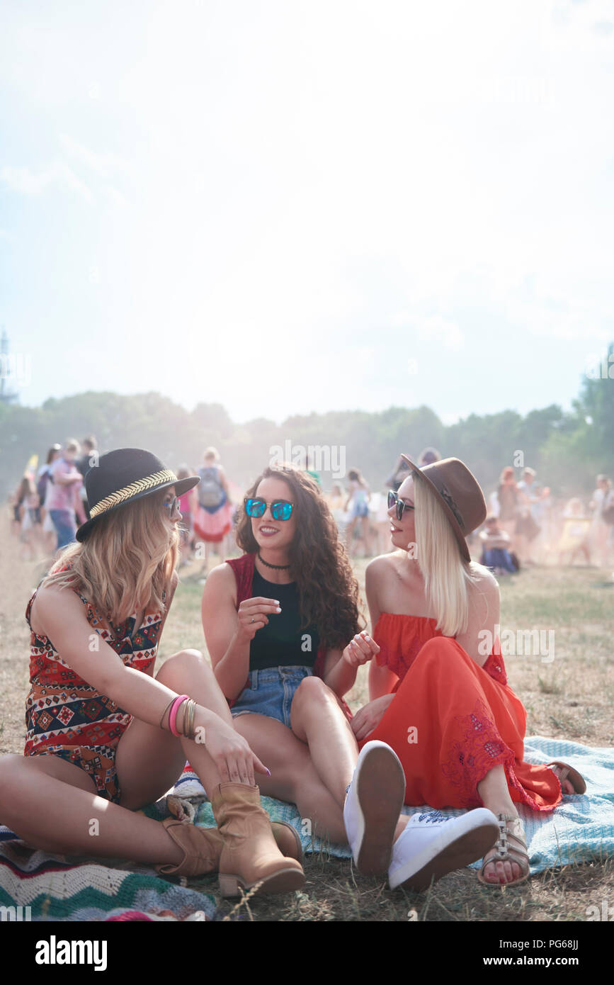 Junge Leute sitzen auf Decke im Music Festival Stockfoto