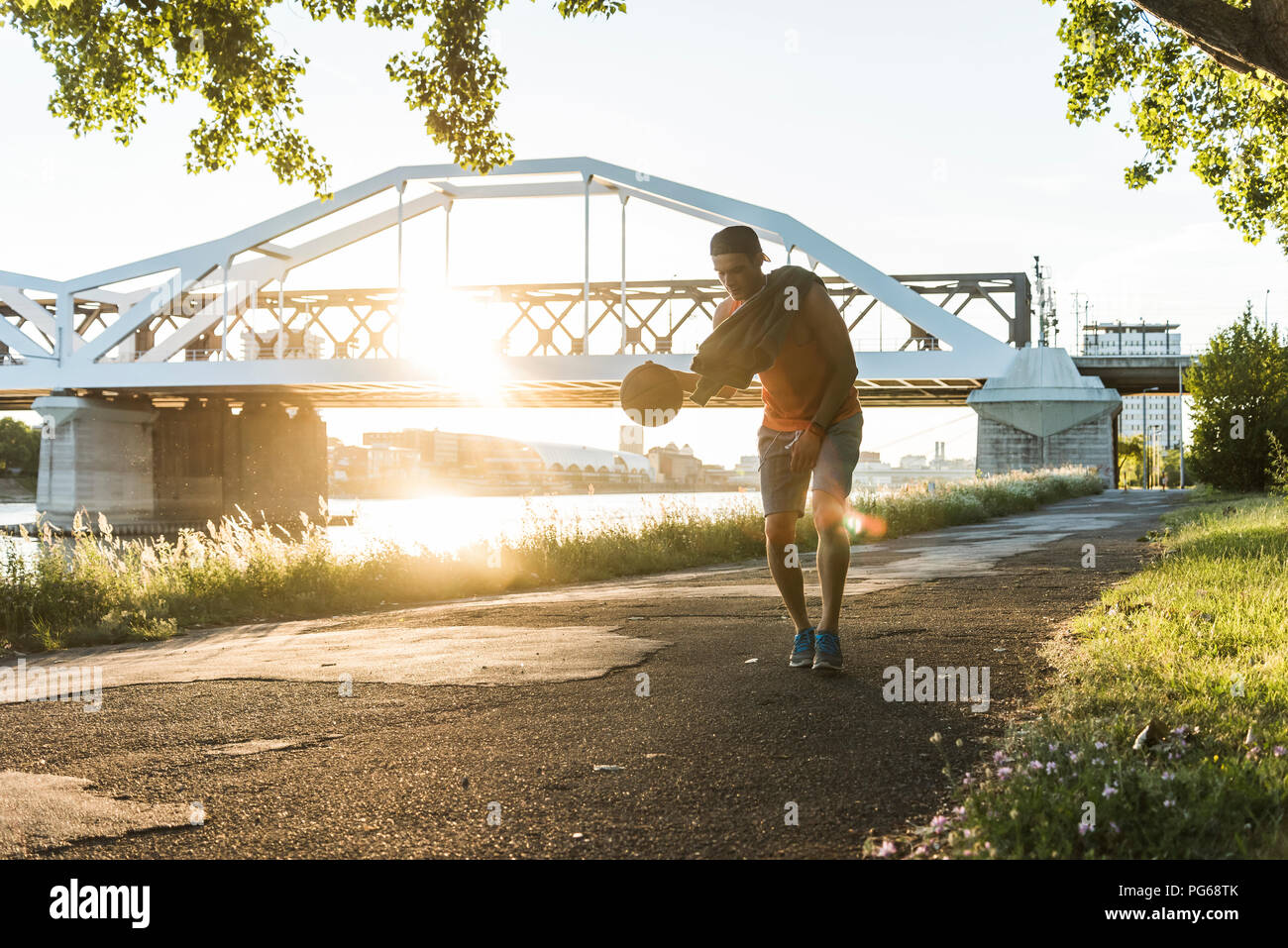Junger Mann basketball Dribbling am Fluss Stockfoto