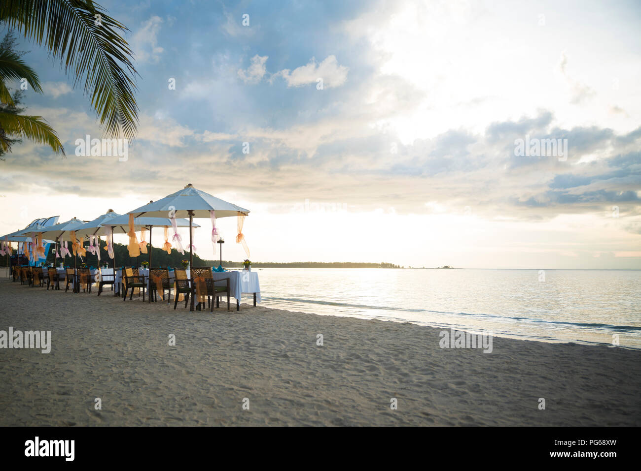 Thailand, Khao Lak, Reihen von gedeckten Tische, Stühle und Sonnenschirme am Strand Stockfoto