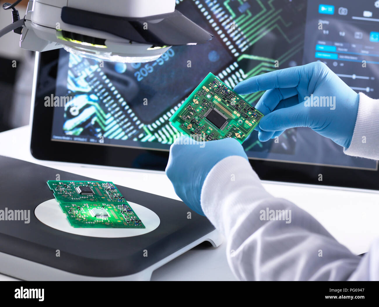 Techniker mit Hilfe eines 3-D Stereo Mikroskop für die Qualitätskontrolle in der Herstellung von Platinen für die Elektronikindustrie Stockfoto