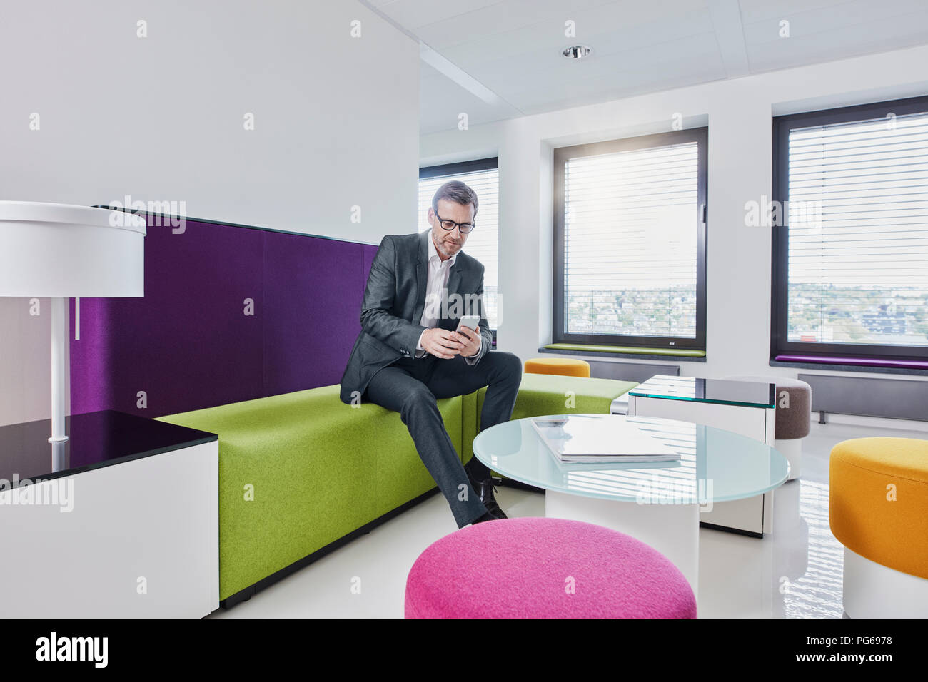 Geschäftsmann mit im Büro lounge Smartphone Stockfoto