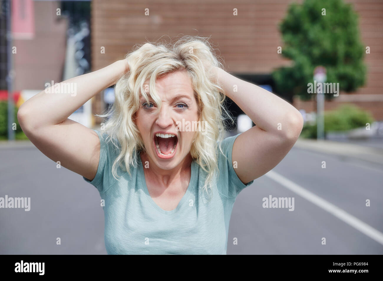 Portrait von schreienden Frau, die ihre Haare ziehen Stockfoto