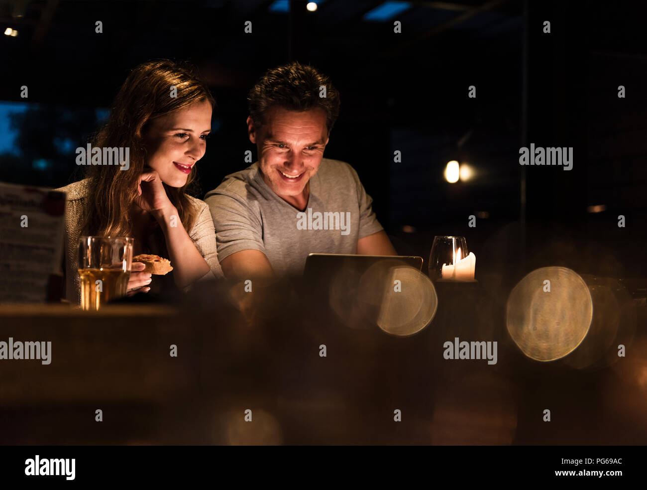 Lächelndes Paar Abendessen im Laptop suchen Stockfoto