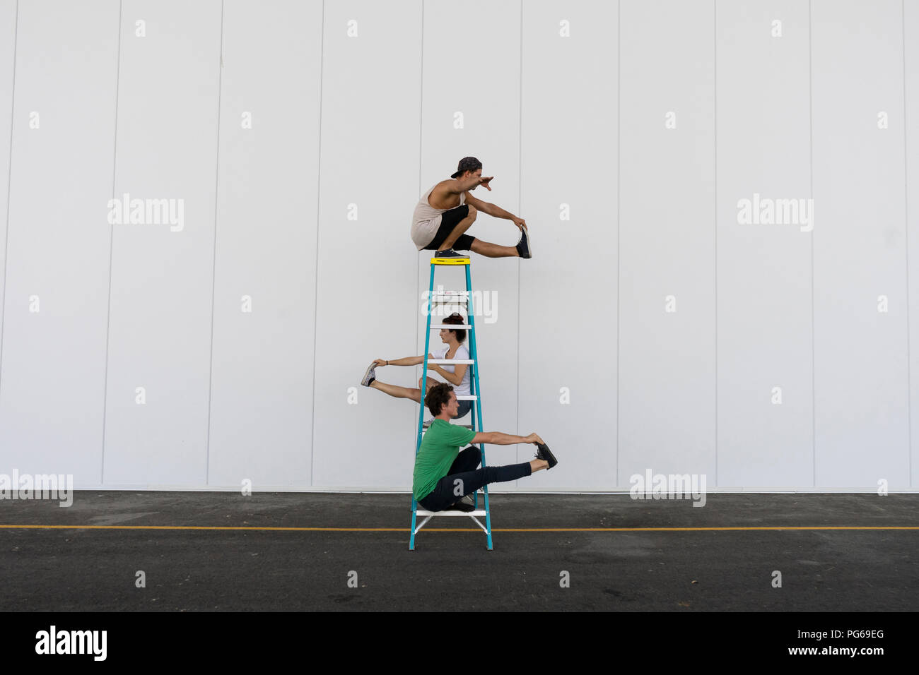Drei Akrobaten Tricks auf einer Leiter Stockfoto