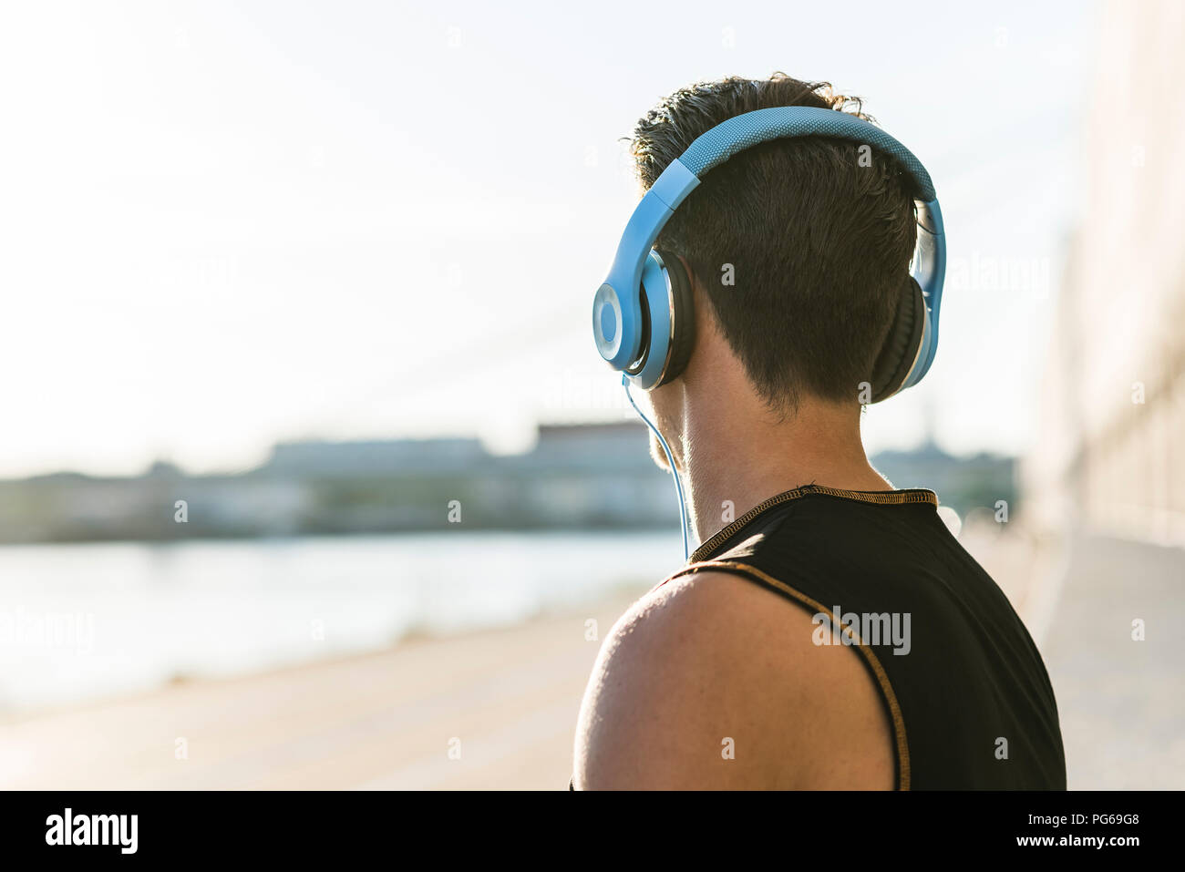 Junger Mann mit Kopfhörern auf Distanz suchen Stockfoto